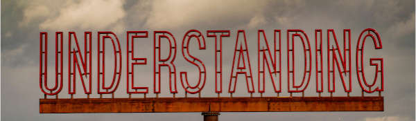 Neon lettering against a cloudy blue sky, reading 'understanding'