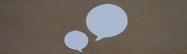 Two white speech bubbles against a sandy brown background