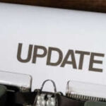 Paper with typed 'UPDATE' in the roller of a typewriter